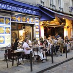 People sit at tables outside a Greek res Restaurants line a street of the Quartier Latin in central Paris.